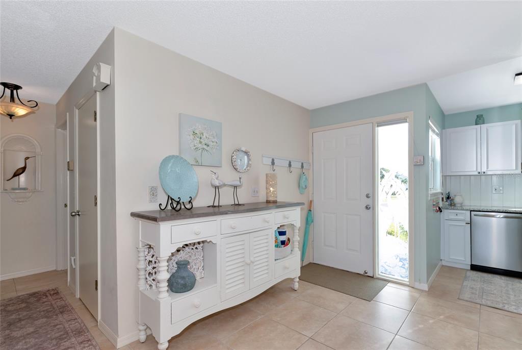 An entryway features a white sideboard, tiled floors, and a door with a side window — 839 AUDUBON DRIVE UNIT 839, BRADENTON, FL
