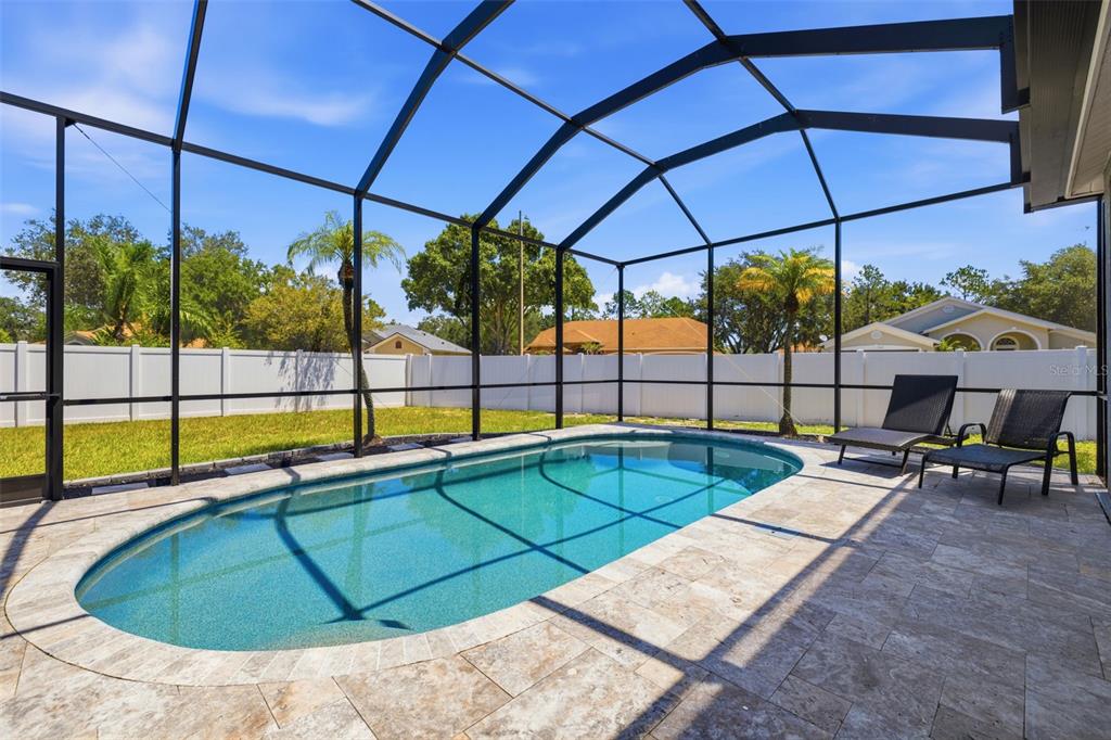 A swimming pool with a stone deck is enclosed by a screened lanai in a backyard — 12020 RUNNING FOX CIRCLE, RIVERVIEW, FL