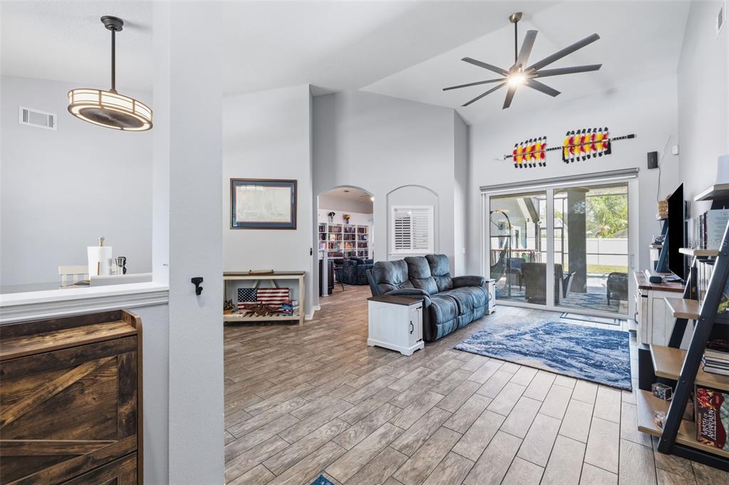 A living room with tile flooring, a ceiling fan, and a sliding glass door to a patio — 12020 RUNNING FOX CIRCLE, RIVERVIEW, FL