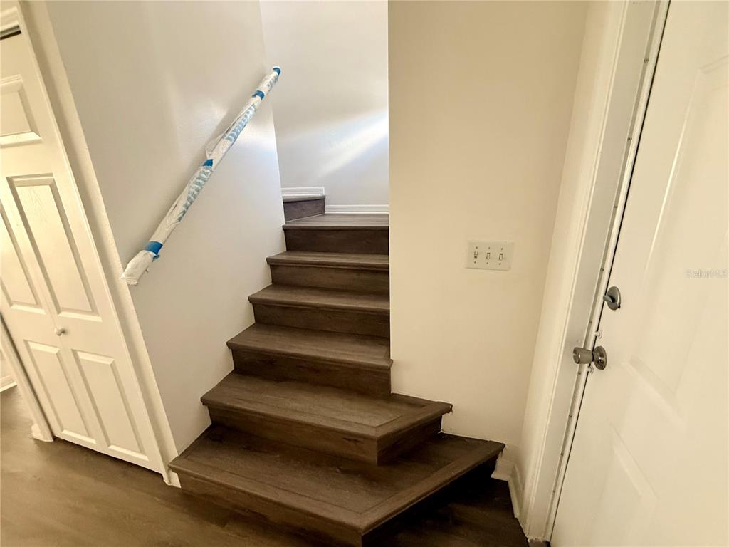 A staircase with dark wood-look steps leads upward between two white doors — 862 CARIBBEAN DRIVE, DAVENPORT, FL