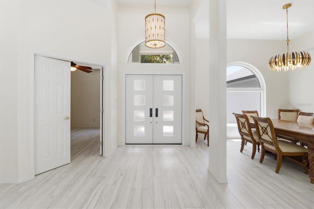 A single-story house with a three-car garage, a palm tree, and a turquoise front door — 21 FIDDLEWOOD COURT, HOMOSASSA, FL