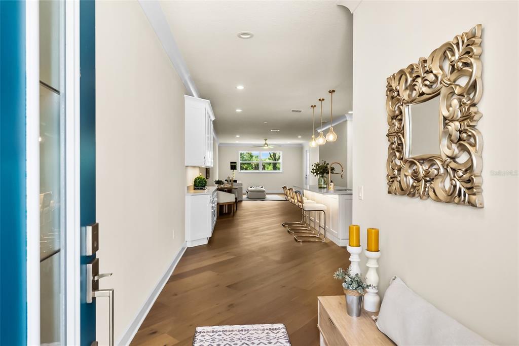 A view from an entryway looking down a hallway toward a kitchen and living area — 207 ATHENIAN WAY, TARPON SPRINGS, FL