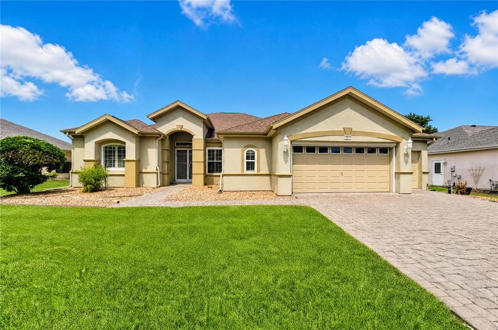 A view from a patio overlooking a grassy golf course under a blue sky — 13500 SE 97TH TERRACE ROAD, SUMMERFIELD, FL