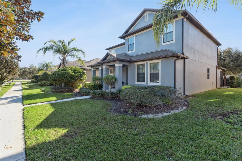A two-story blue house with a covered front porch and a landscaped front yard — 13232 LONGACRE DRIVE, WINDERMERE, FL
