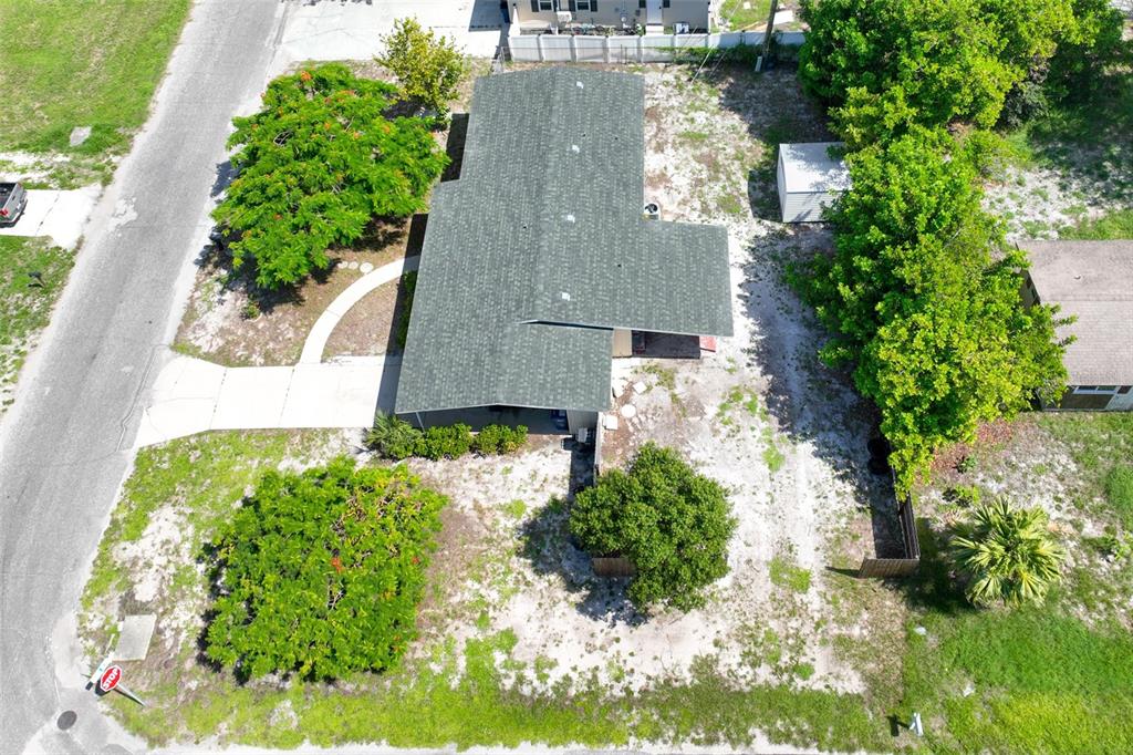 A single-story yellow house with brown shutters sits behind a large tree in a yard — 6515 3RD STREET COURT W, BRADENTON, FL