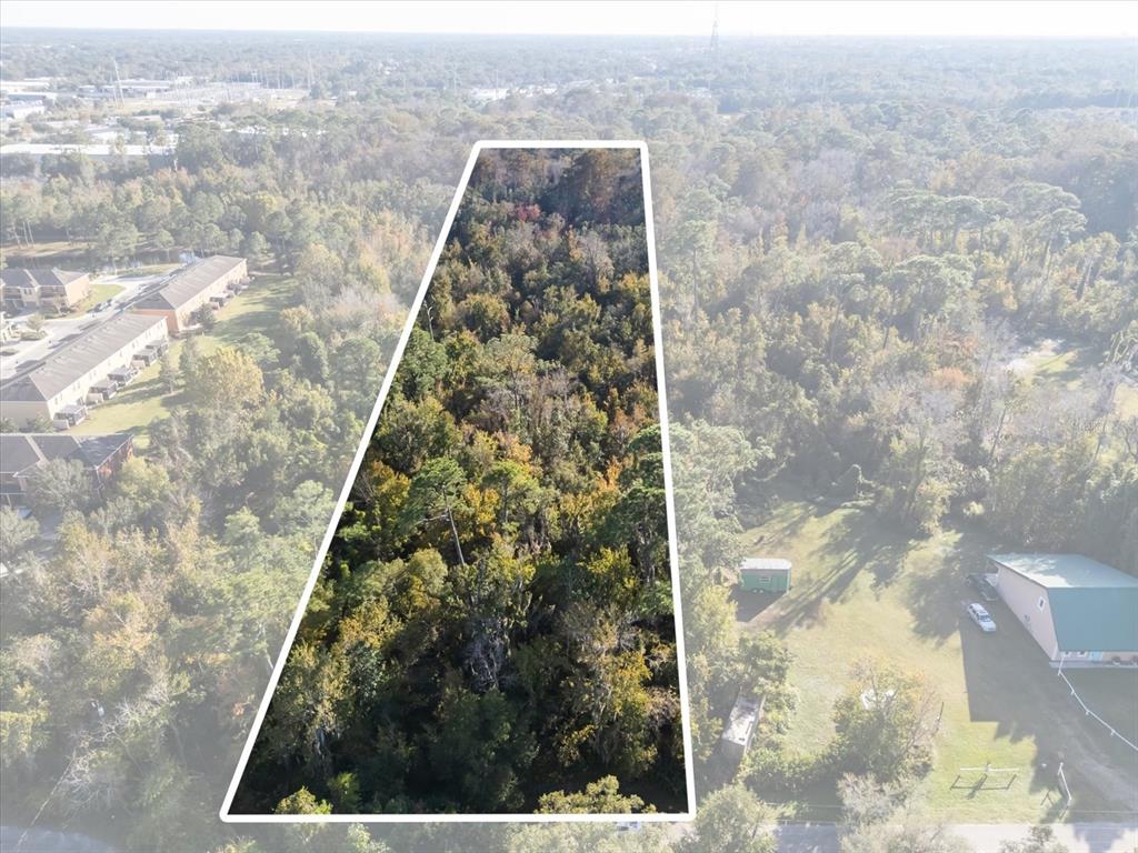 An aerial view shows a wooded lot outlined in white next to a residential area — HILL TOP DRIVE, LAKE MARY, FL