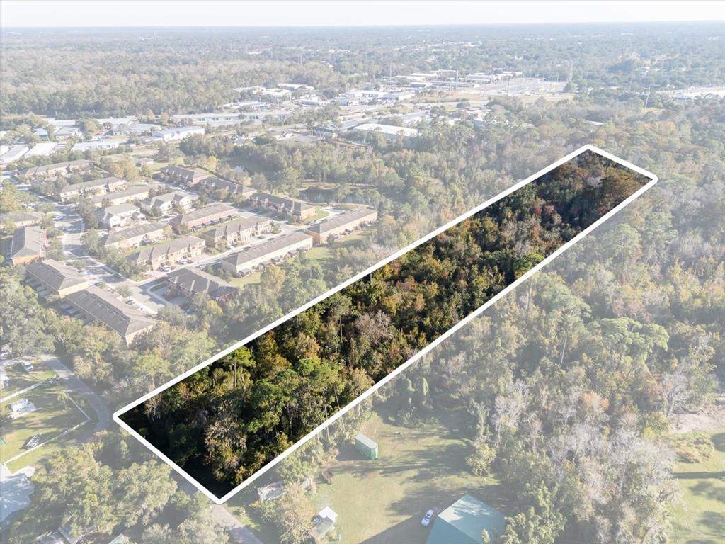 An aerial view shows a rectangular, wooded plot of land highlighted against surrounding residential buildings — HILL TOP DRIVE, LAKE MARY, FL