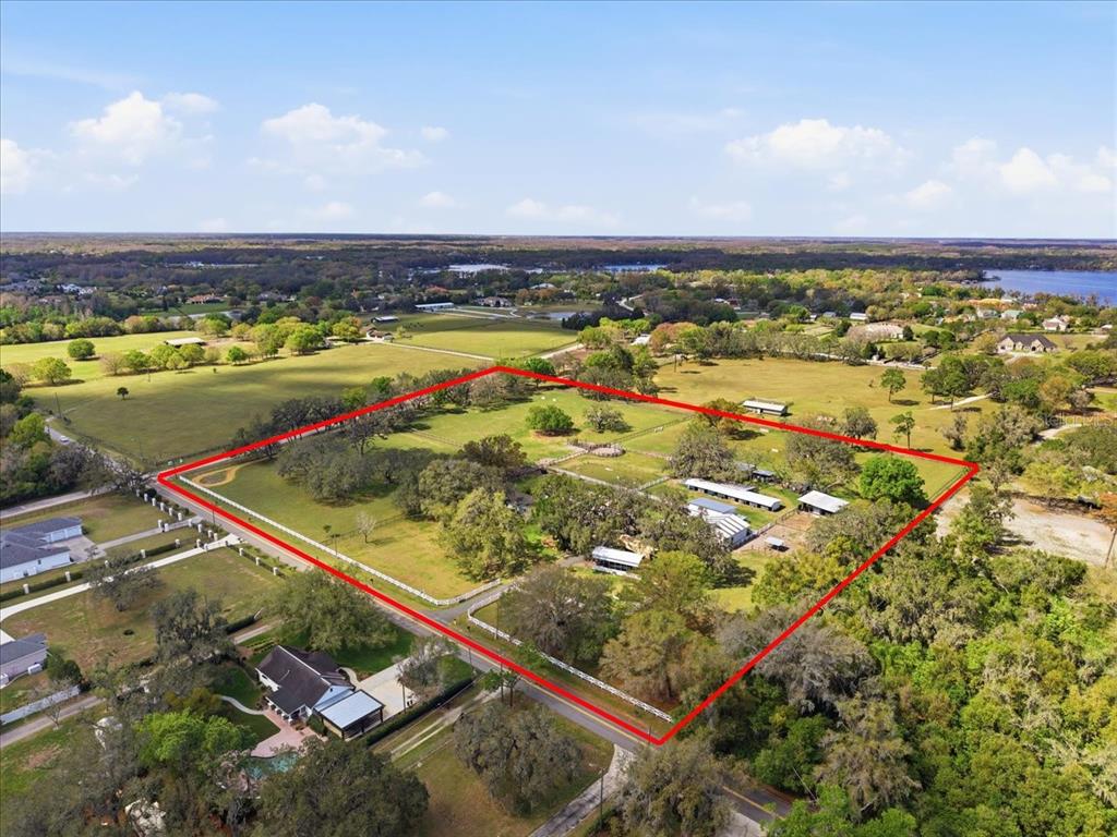 An aerial view shows a fenced rural property with several outbuildings and mature trees — 9449 ROBERTS ROAD, ODESSA, FL