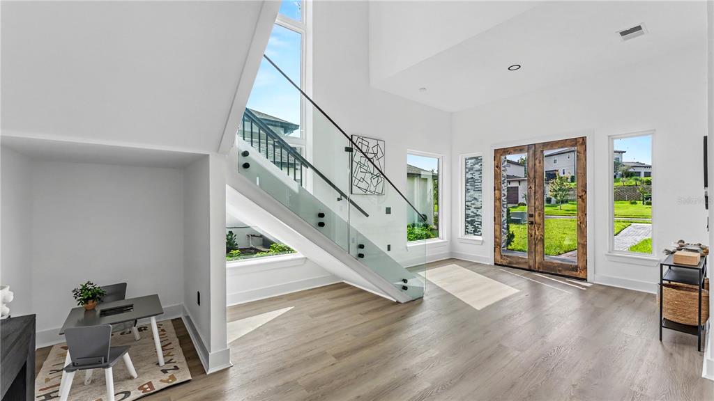 The rear exterior of a modern two-story house features a covered patio and upper balcony — 156 CALADIUM AVENUE, LAKE ALFRED, FL