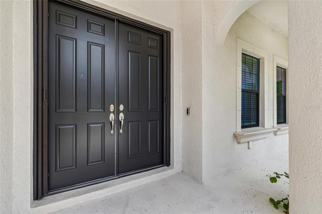 A two-story Mediterranean-style house with a tile roof, three-car garage, and a concrete driveway — 2719 CALVANO DRIVE, LAND O LAKES, FL