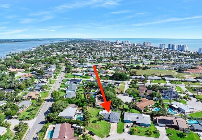 An aerial view shows a residential neighborhood with a red arrow pointing to a house — 91 ORMWOOD DRIVE, ORMOND BEACH, FL