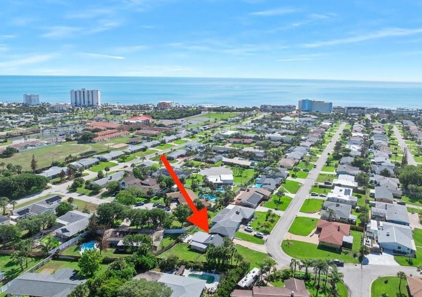 An aerial view shows a residential neighborhood near the ocean with a red arrow pointing down — 91 ORMWOOD DRIVE, ORMOND BEACH, FL