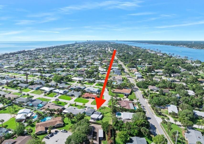 An aerial view shows a residential neighborhood with a red arrow pointing to a house — 91 ORMWOOD DRIVE, ORMOND BEACH, FL