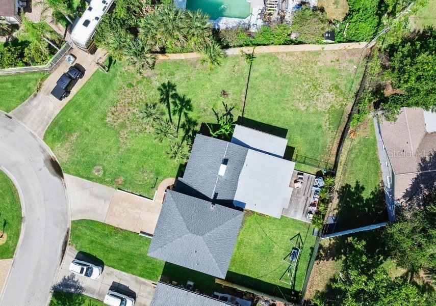 An aerial view shows a house with a gray roof, a large yard, and a driveway — 91 ORMWOOD DRIVE, ORMOND BEACH, FL