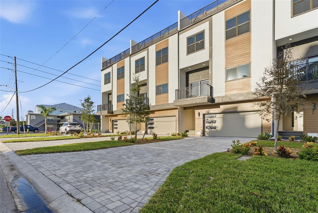A modern kitchen with white cabinets, stainless steel appliances, and an island overlooks a balcony — 11605 1ST STREET E UNIT B3, TREASURE ISLAND, FL