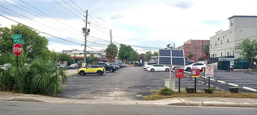 An outdoor parking lot features a solar-powered payment kiosk and a stop sign — 94 SW FT KING, OCALA, FL