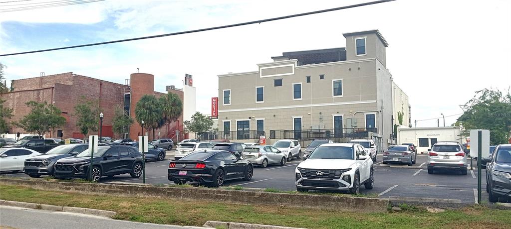 A parking lot sits in front of a multi-story building and a brick structure — 94 SW FT KING, OCALA, FL