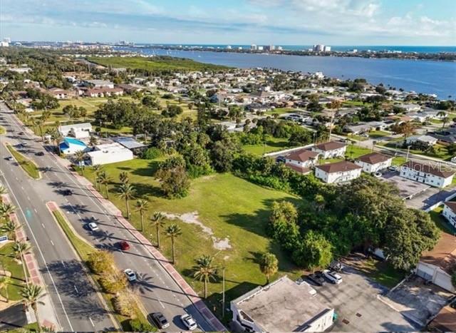 An aerial view shows a vacant grassy lot situated between a road and residential buildings — 1745 S RIDGEWOOD AVENUE, SOUTH DAYTONA, FL