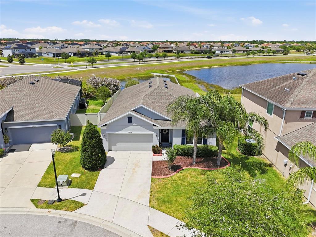 An aerial view of a suburban house with a two-car garage and a backyard pond — 11908 GREENCHOP PLACE, RIVERVIEW, FL