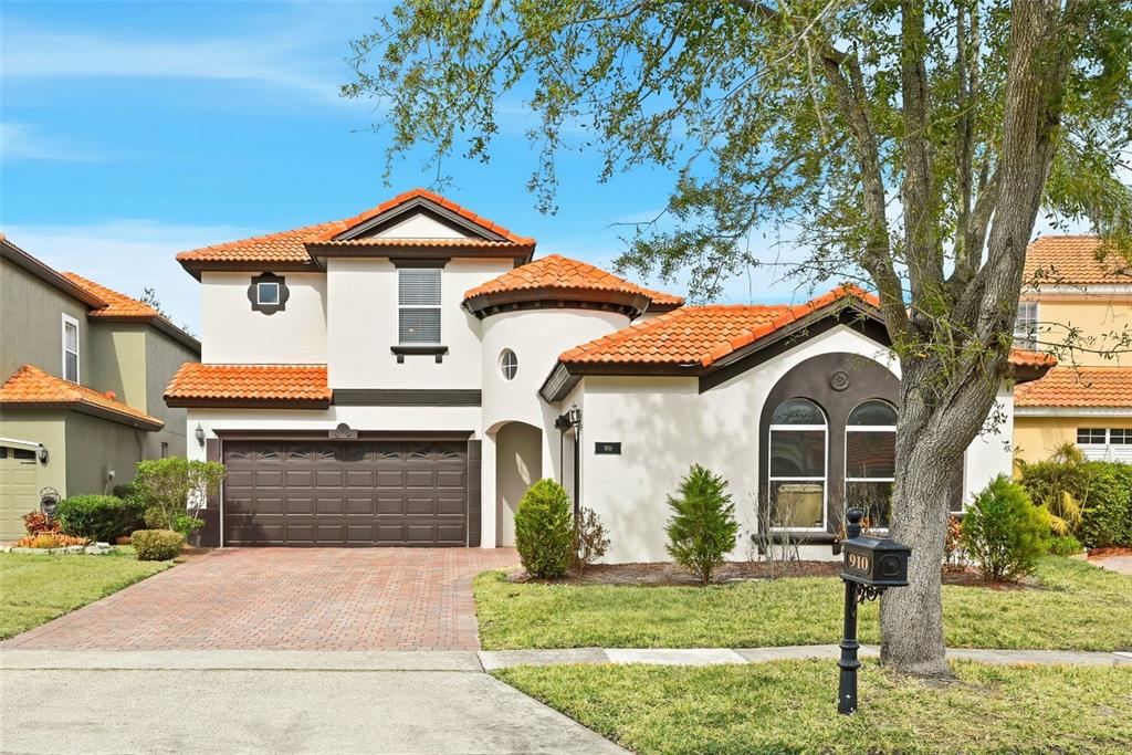 An aerial view shows a two-story house with a red tile roof and a driveway — 910 LASCALA DRIVE, WINDERMERE, FL