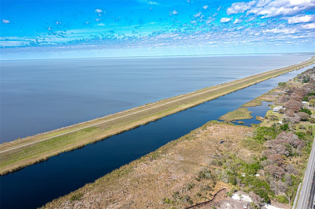 An aerial view shows a canal running parallel to a large lake and a road — 15460 SW CONNERS HIGHWAY, OKEECHOBEE, FL