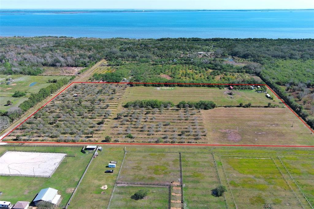 An aerial view shows a large, rectangular plot of land outlined in red near water — 0 DAVIS ROAD, MIMS, FL