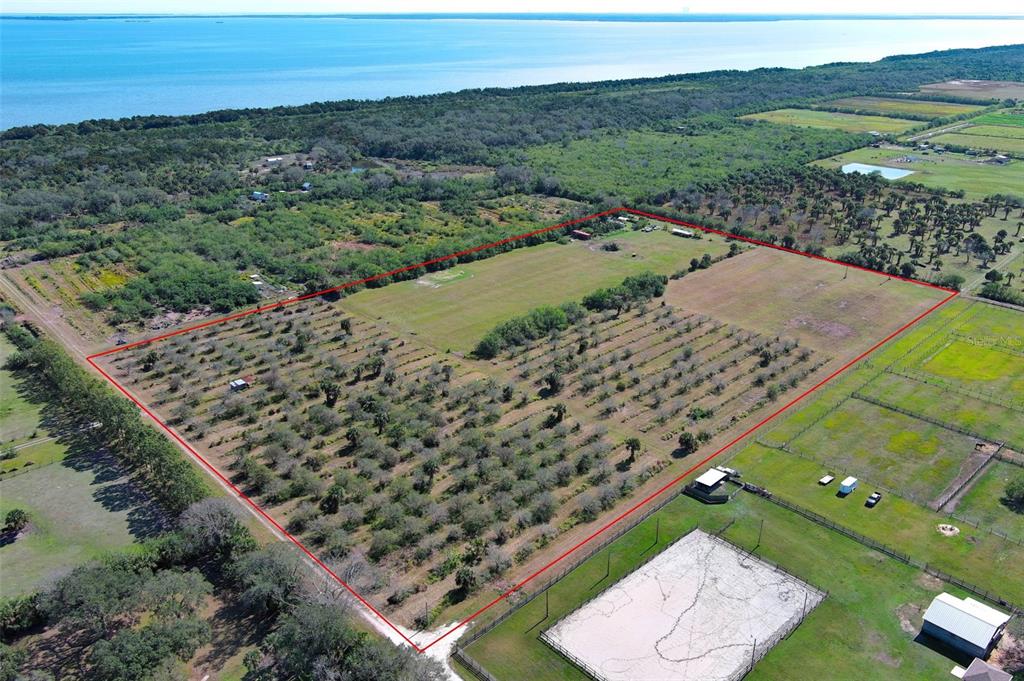 An aerial view shows a large, rectangular plot of land outlined in red near water — 0 DAVIS ROAD, MIMS, FL