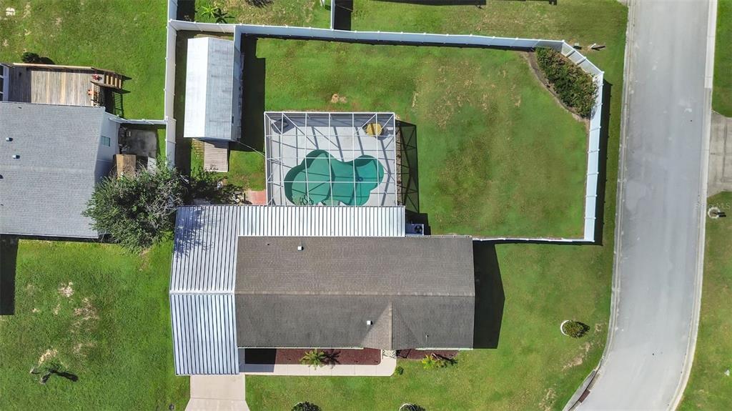 An aerial view shows a house with a screened-in pool and a fenced backyard — 490 LINDSEY DR, LAKELAND, FL