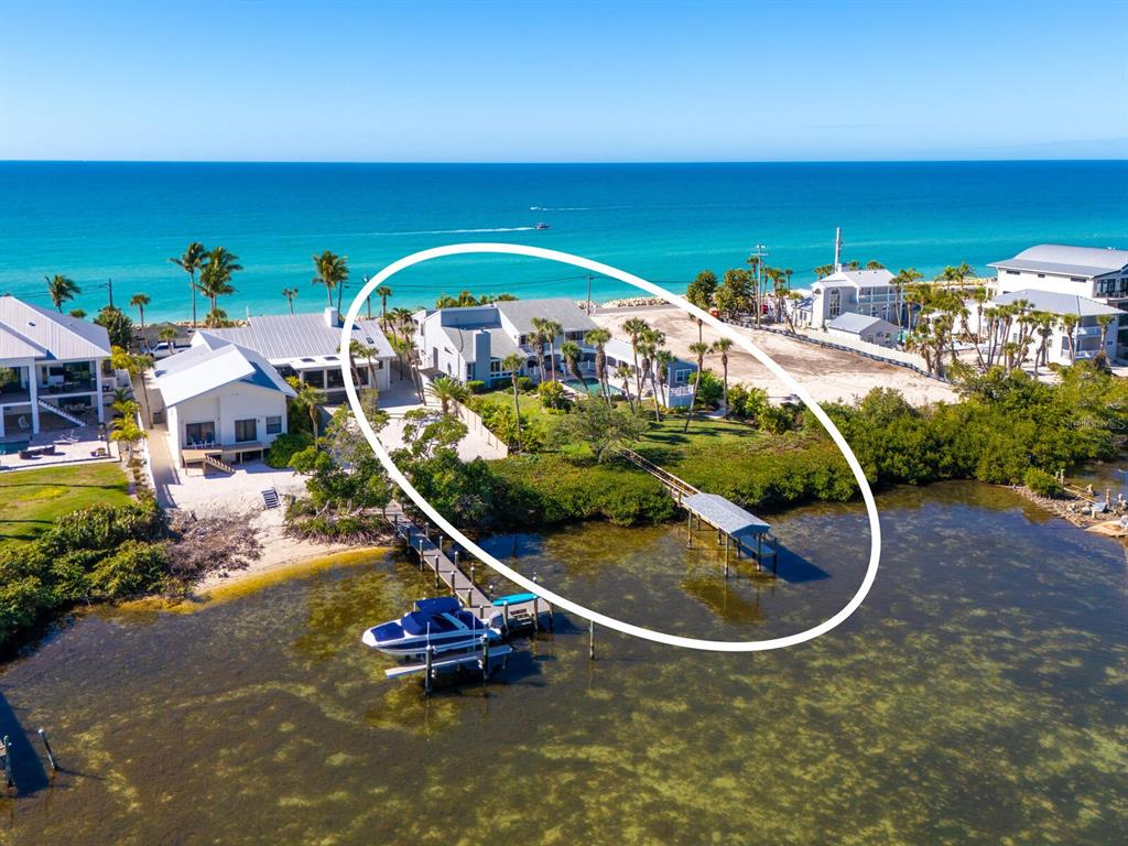 An aerial view of a waterfront house with a private dock and boat lift — 3240 CASEY KEY ROAD, NOKOMIS, FL