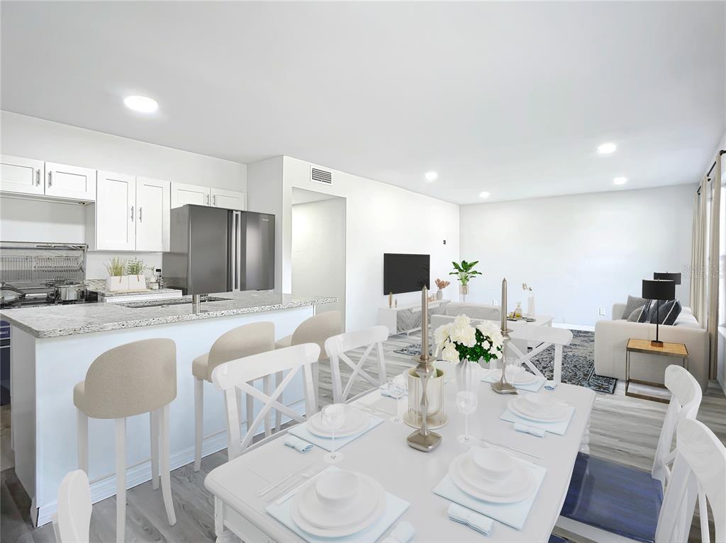 This is a digitally staged open-concept kitchen, dining area, and living room with white cabinetry — 933 MARION STREET, DAYTONA BEACH, FL