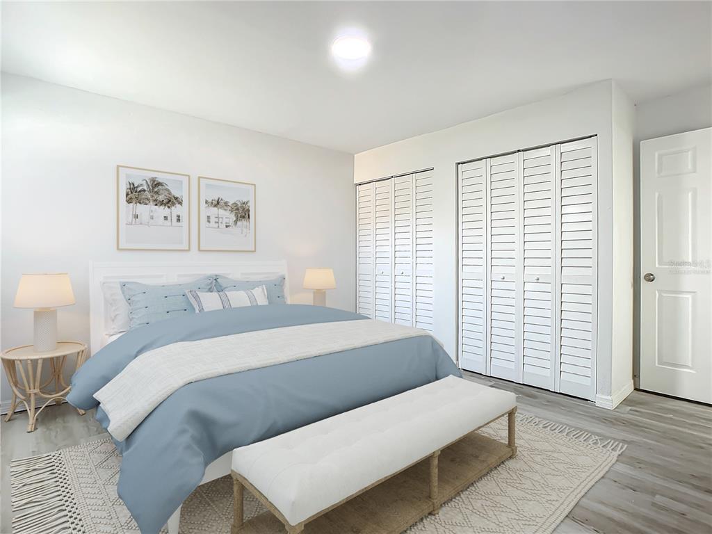 A bedroom features a blue bed, white louvered closet doors, and a light-colored area rug — 933 MARION STREET, DAYTONA BEACH, FL