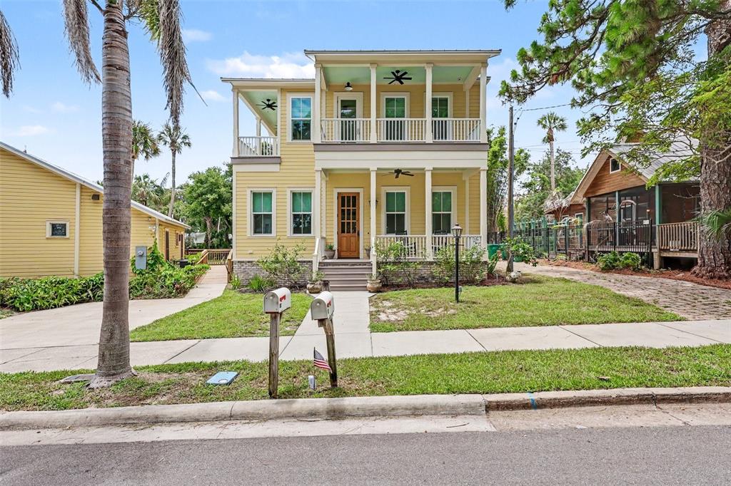 A two-story yellow house with a front porch, balcony, and two mailboxes in the yard — 7 MITCHELL STREET, COCOA, FL