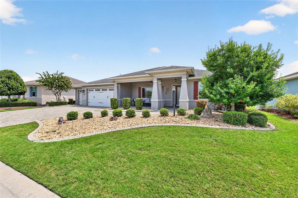 A single-story house with a paved driveway, a gravel front yard, and a covered porch — 8745 SW 94TH AVENUE, OCALA, FL