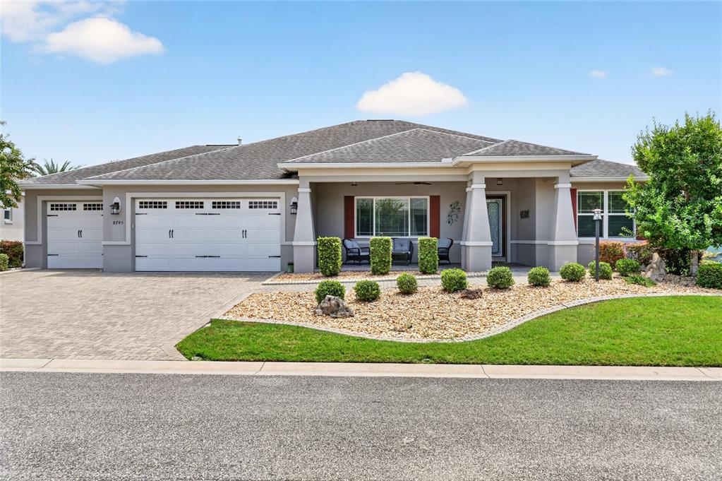A single-story house with a white garage, covered porch, and landscaped front yard — 8745 SW 94TH AVENUE, OCALA, FL