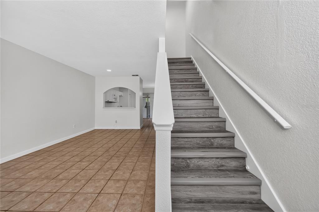 An open living area features light-colored tile flooring and a kitchen pass-through with an archway — 4214 PLANTATION COVE DRIVE, ORLANDO, FL