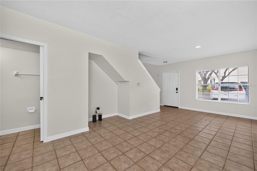 A kitchen features white cabinets, white appliances, and light-colored tile flooring — 4214 PLANTATION COVE DRIVE, ORLANDO, FL
