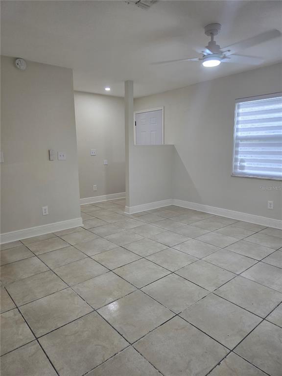A room with light-colored tile flooring, a ceiling fan, and a partial wall divider — 3064 SAINT PAUL DRIVE UNIT 3064, WINTER HAVEN, FL
