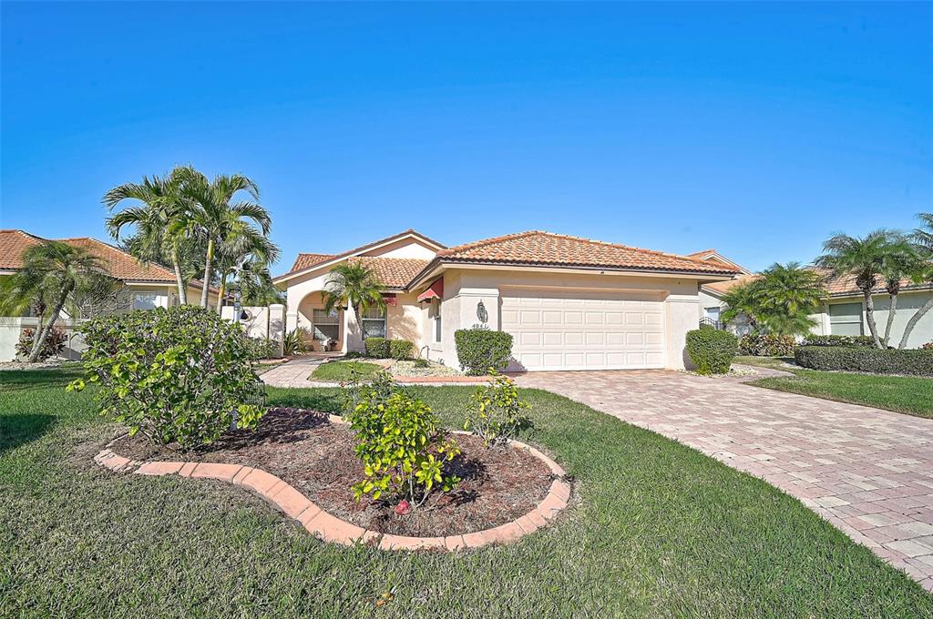 A single-story house with a tiled roof, two-car garage, and landscaped front yard — 4041 MURFIELD DRIVE E, BRADENTON, FL