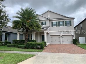 A two-story suburban house with a brick driveway, two-car garage, and a large palm tree — 15607 PORTER ROAD, WINTER GARDEN, FL