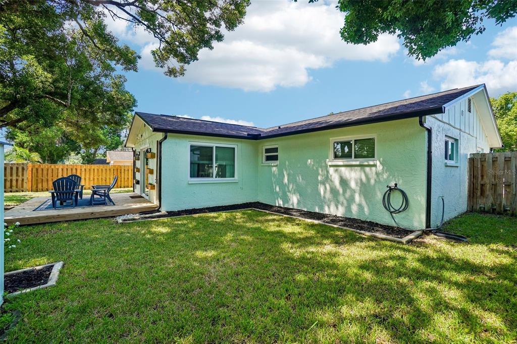 A living room features a large gray sectional sofa, beige carpeting, and a ceiling fan — 3420 PALOMA DRIVE, HOLIDAY, FL