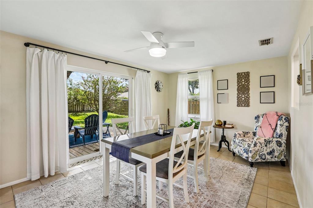 A dining room features a table, chairs, a ceiling fan, and sliding glass doors to a patio — 3420 PALOMA DRIVE, HOLIDAY, FL