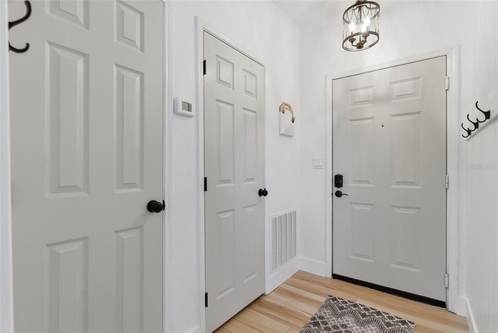 A view from a hallway looking into a kitchen with gray cabinets and a dining area — 4323 BAYSIDE VILLAGE DRIVE UNIT 312, TAMPA, FL
