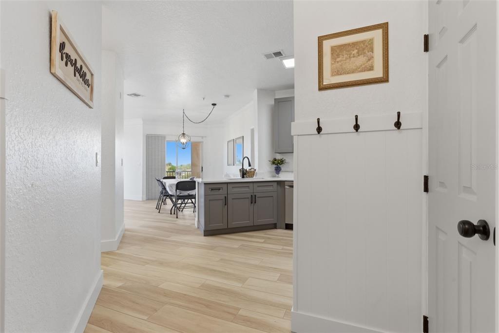 A modern kitchen features gray cabinets, stainless steel appliances, white countertops, and light wood flooring — 4323 BAYSIDE VILLAGE DRIVE UNIT 312, TAMPA, FL