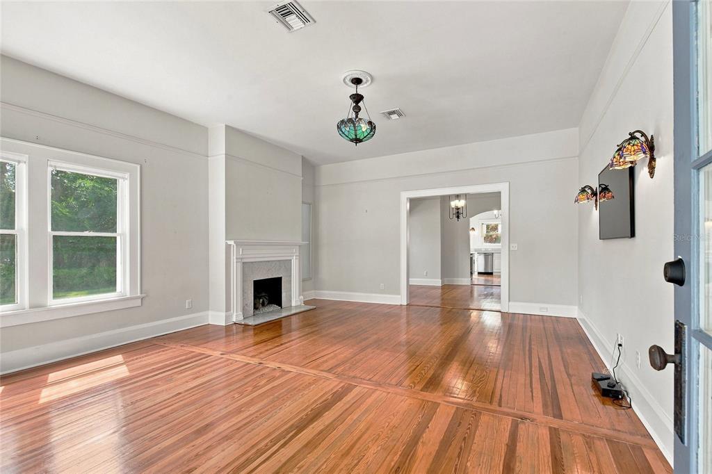 A living room with hardwood floors, a fireplace, and a stained glass light fixture — 929 VISTABULA STREET, LAKELAND, FL