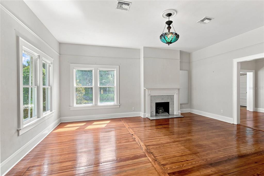 A living room features hardwood floors, a fireplace, and a decorative hanging light fixture — 929 VISTABULA STREET, LAKELAND, FL