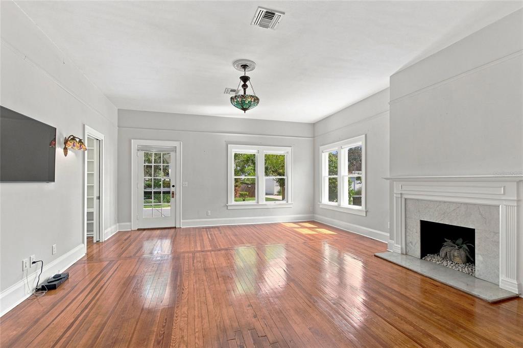 A living room features hardwood floors, a fireplace, and a stained-glass chandelier — 929 VISTABULA STREET, LAKELAND, FL