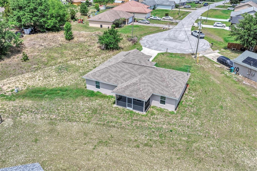 An aerial view shows a single-story house with a screened-in porch and a large yard — 17 CEDAR TREE RUN, OCALA, FL
