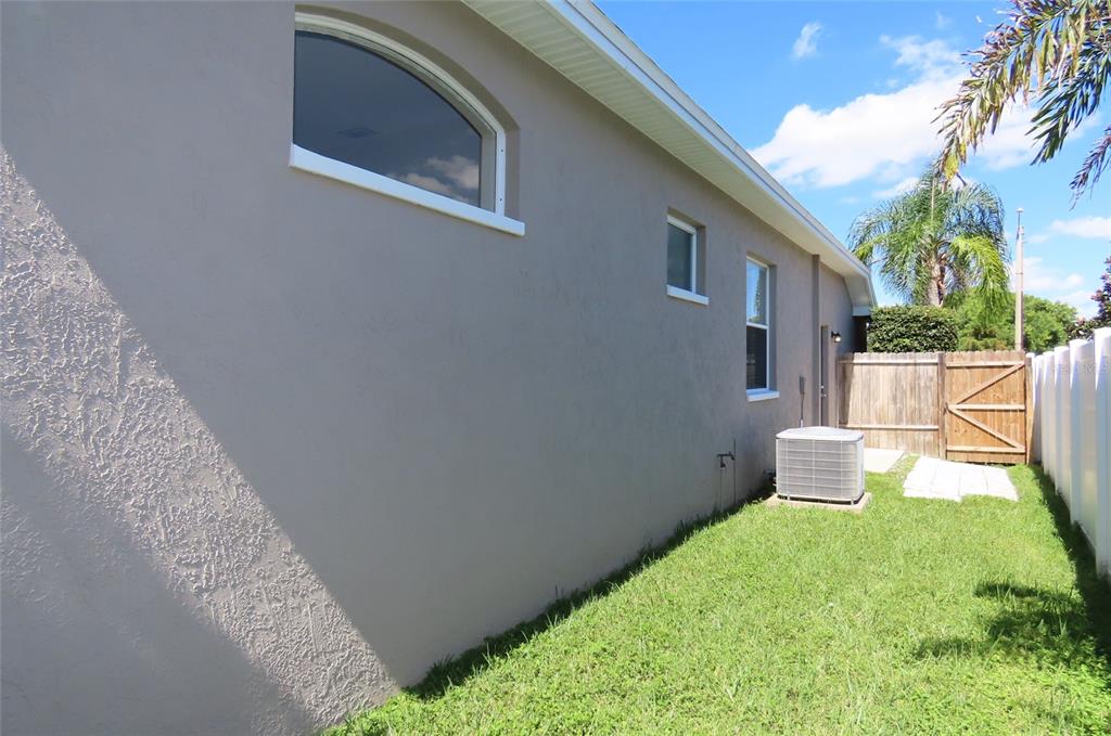 A room with gray walls, wood-look flooring, a ceiling fan, sliding glass doors, and an arched window — 1801 MAPLELEAF BOULEVARD, OLDSMAR, FL