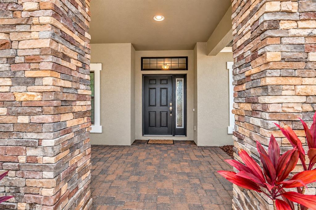 An empty room with dark wood-look flooring, white walls, a chandelier, and a staircase — 1741 CHERRY WALK ROAD, LUTZ, FL