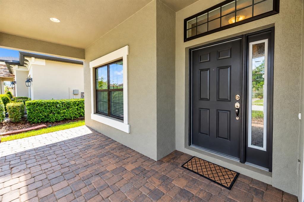 An open-concept kitchen and living area features white cabinetry, stainless appliances, and dark wood flooring — 1741 CHERRY WALK ROAD, LUTZ, FL
